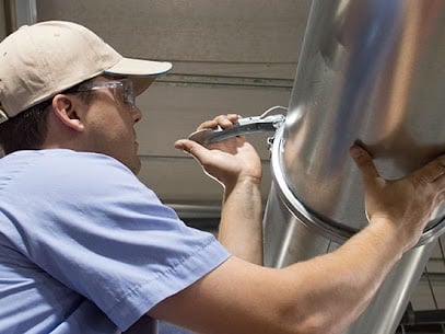 A technician clamping down Nordfab duct pipe.